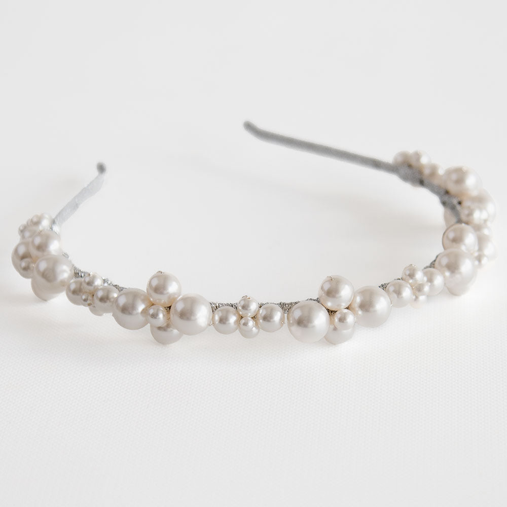 pearls wired together to form different shapes and put together in a pattern on a headband.