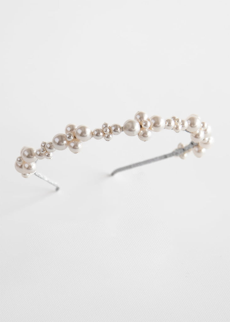 Head band worn for weddings with lots of pearls in a pattern along the length of the design. 