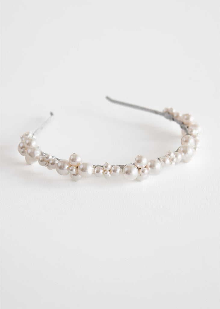 Simple pearl headband. Pearls are clustered together in pattern along the headband. 