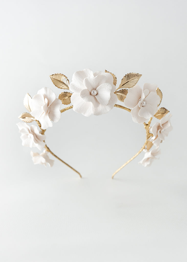 Floral style headpiece with flowers that have pearl centers and leaves.