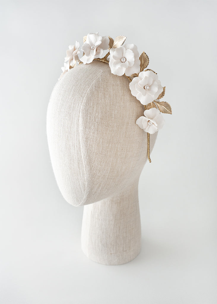 eight petal handmade flowers on a headband with leaves backing he flowers.