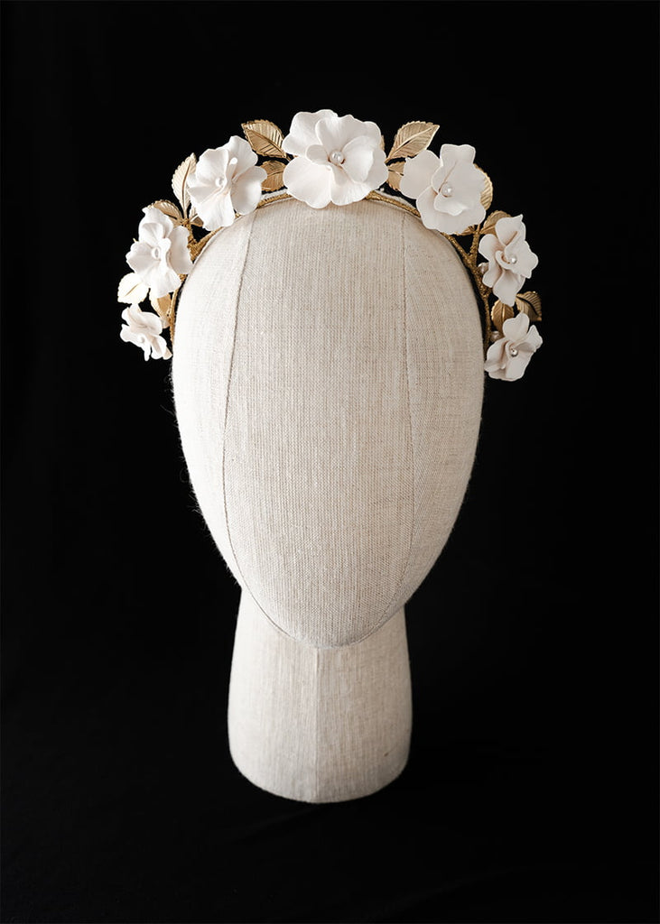 Headband with seven medium handmade flowers with metal leaves at the back.