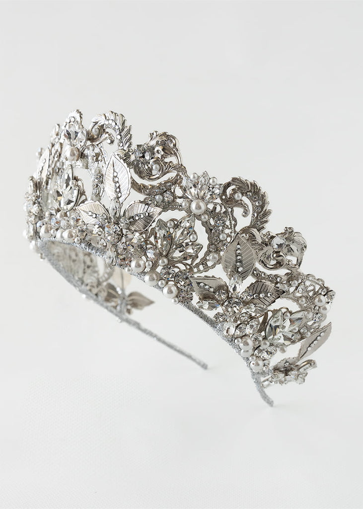 Olympia statement tiara is 6 cm tall with an abundance of hand beading of rhinestone and pearls. It has metal filigrees and leaves for the base of the design.