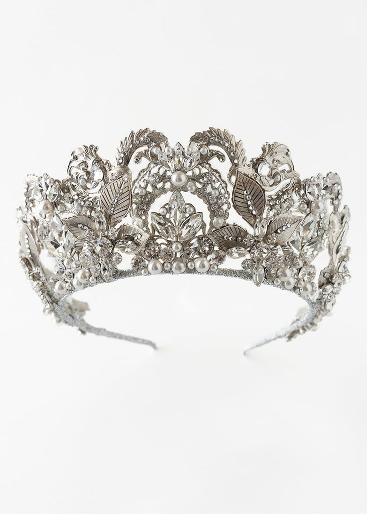 Olympia statement tiara is 6 cm tall with an abundance of hand beading of rhinestone and pearls. It has metal filigrees and leaves for the base of the design.